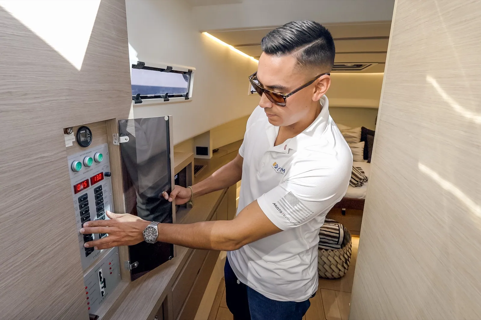 A YMS technician working at an interior electrical panel inside a lit salon
