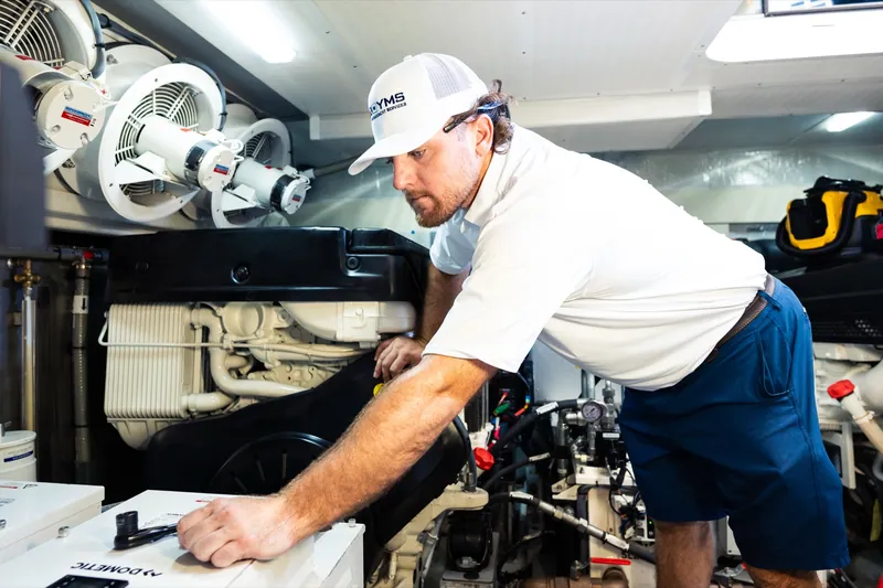 A YMS technician working on an engine in a yacht engine room