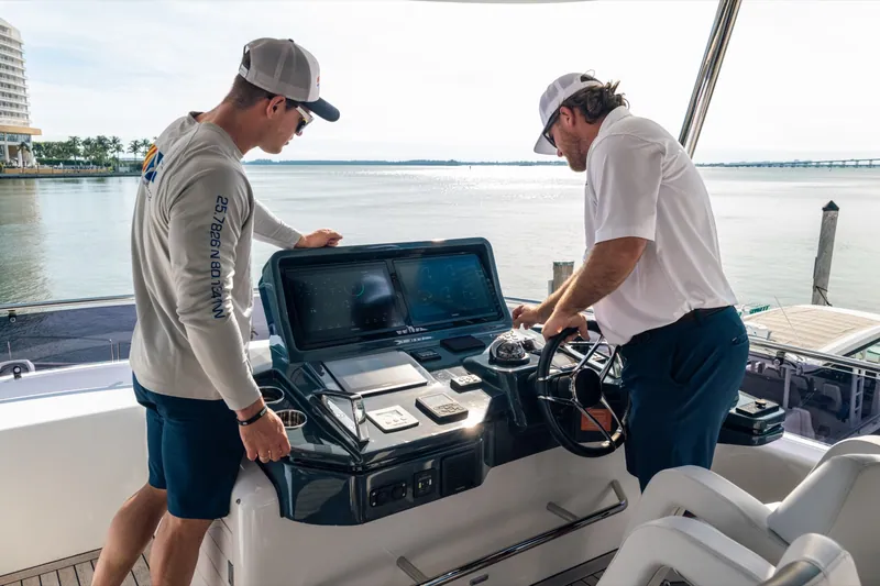 Two YMS captains at the helm of a yacht on the water